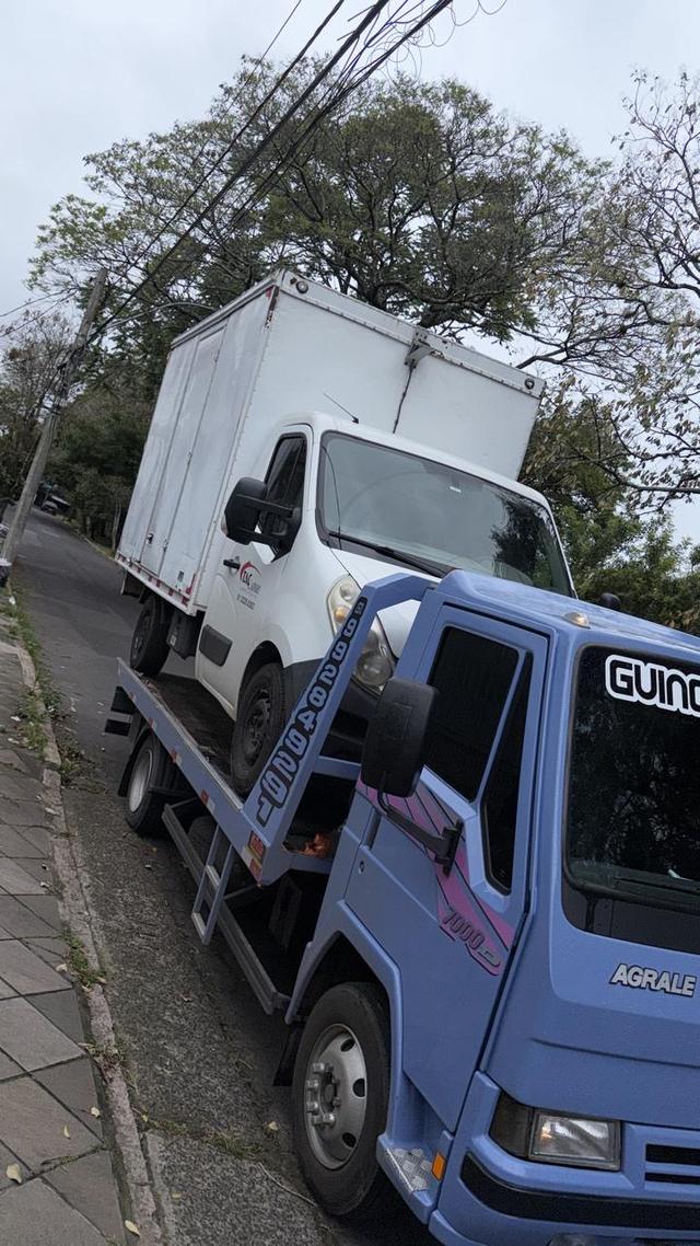 Caminhão baú branco sendo removido pelo guincho